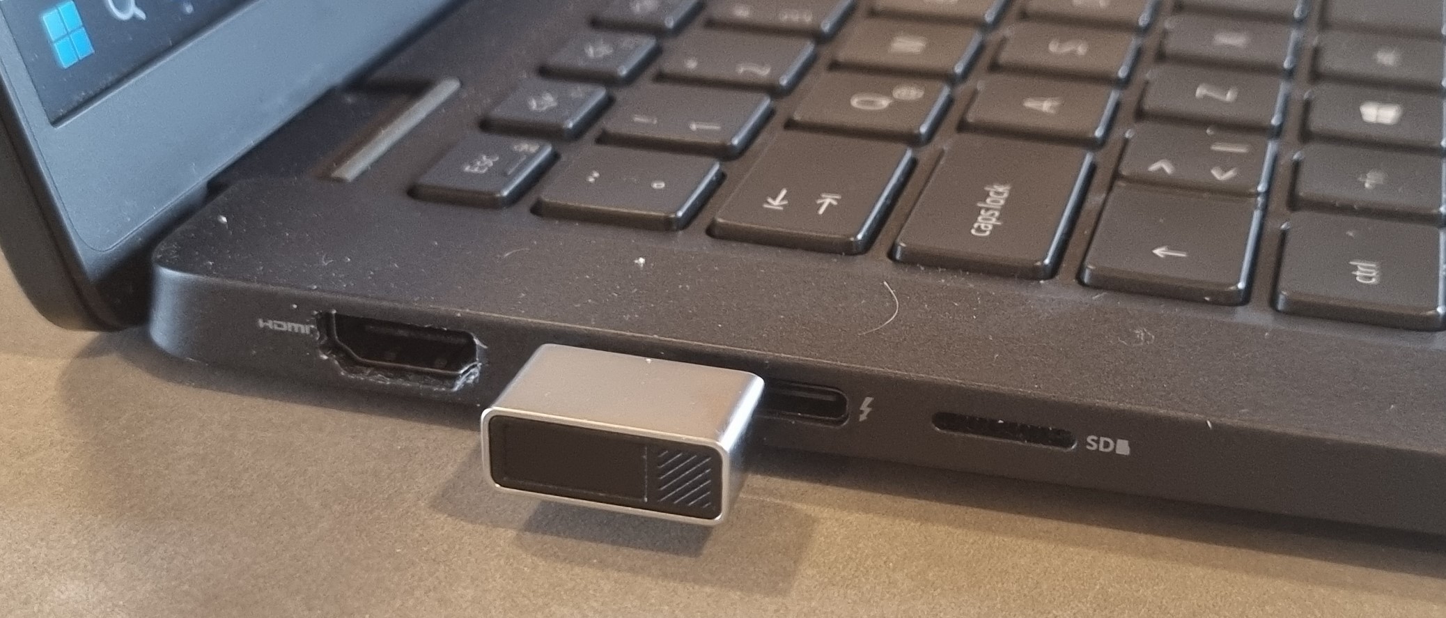 Fingerprint reader USB C style, scanner on end. shown plugged into computer